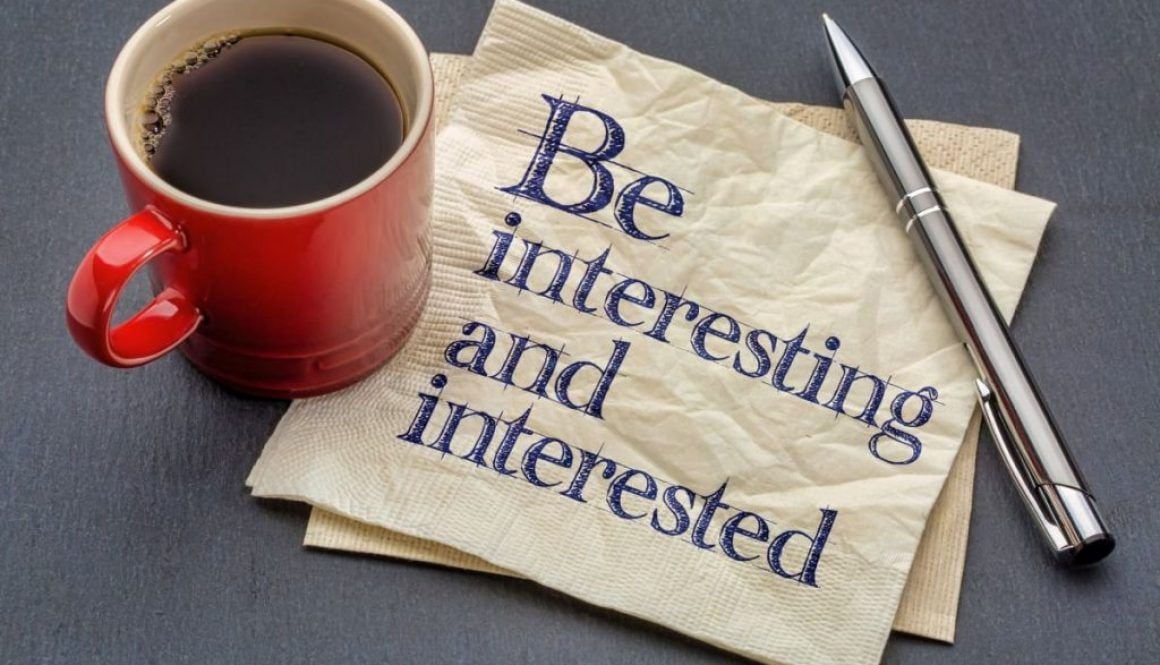 picture of a cup of coffee, a pen, and a napkin that reads "be interesting and interested"